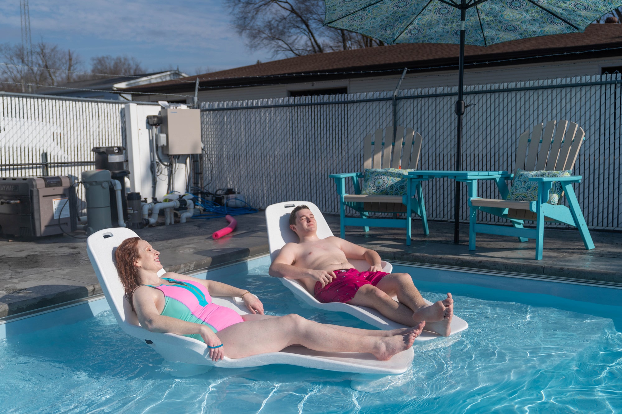 Two people enjoying time in a fiberglass pool.